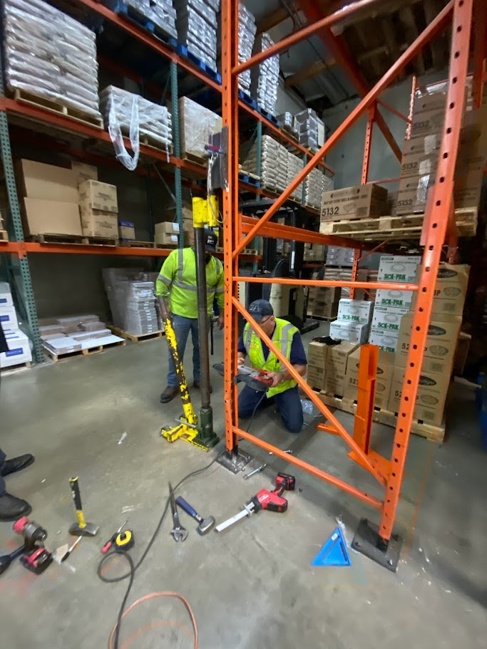 two people repairing pallet rack in a warehouse in Los Angeles